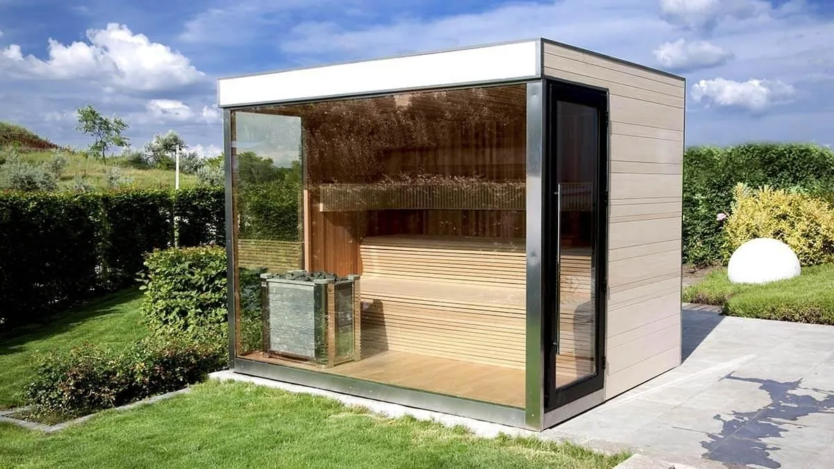 Aussensauna mit Glasfront, Edelstahlrahmen und hellem Holz im Garten