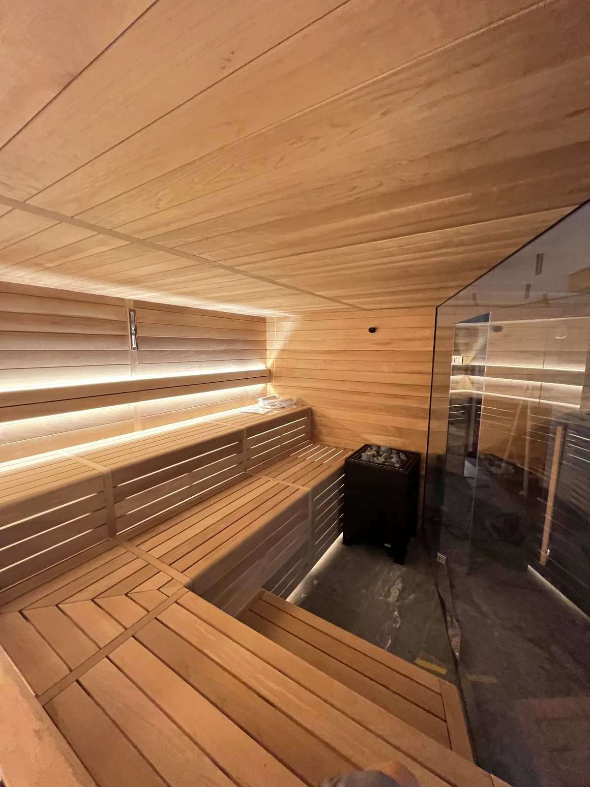 Sauna in Samedan mit Glasfront, Eckbank und Lichtband hinter der Rückenlehne