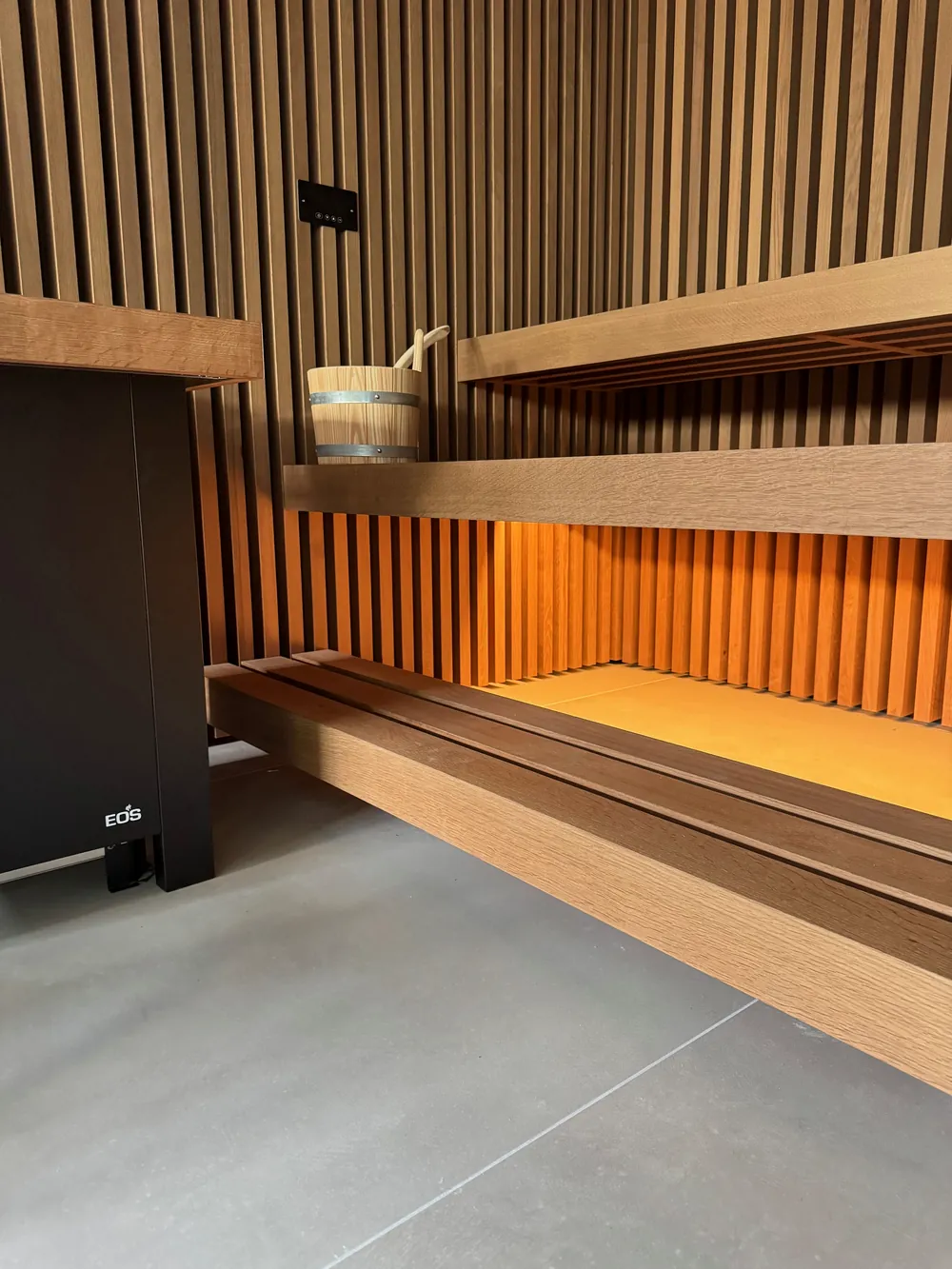 Saunabank mit indirektem Lichtband, Aufgusskübel und EOS-Saunaofen